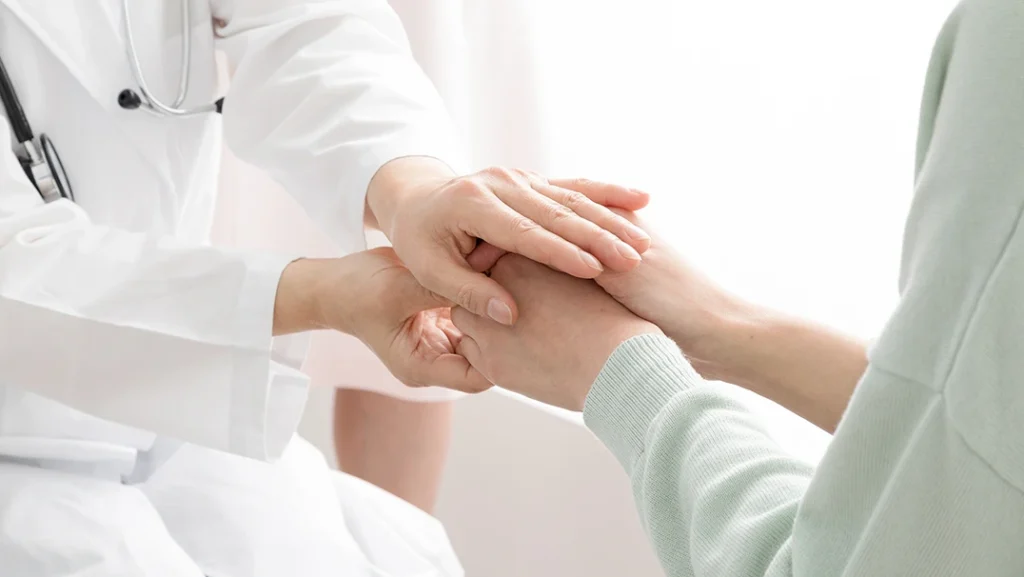 患者に手を重ねる医師の写真