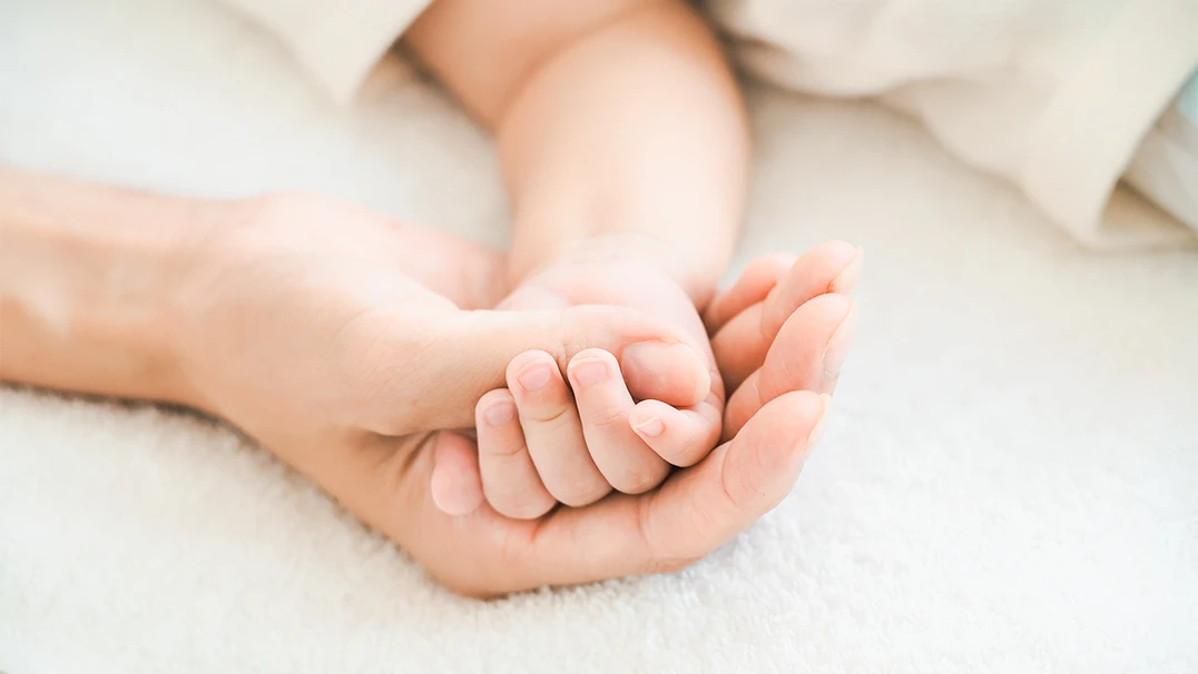 赤ちゃんの手に触れている写真